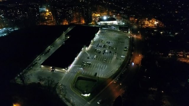Parking lot at nighttime in a city, aerial shot in 4k