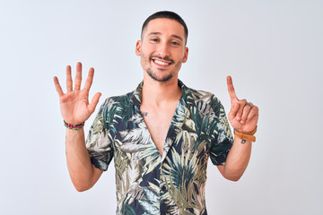 Young handsome man wearing Hawaiian summer shirt over isolated background showing and pointing up with fingers number six while smiling confident and happy.