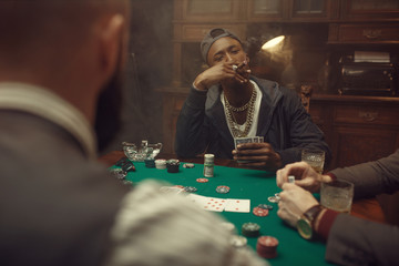 Poker players at gaming table with green cloth