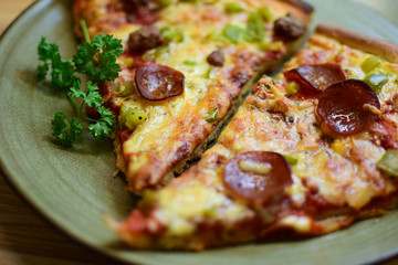 Pieces of delicious pizza with sausage lie on a plate. Selective focus, bokeh