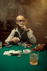 Bearded poker player with cigar, casino