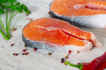 freshly cut raw salmon with spices on wooden surface