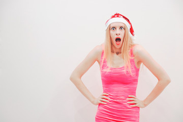 blonde in a red Christmas hat and pink dress shows different emotions on her face