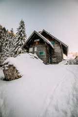 wooden house in winter forest in austria