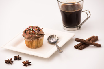 Chocolate Muffin with hot Cup of coffee, cinnamon sticks and Anise stars on a white background
