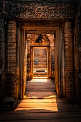 A woman climing the stairs of the ruins of temples in cambodia