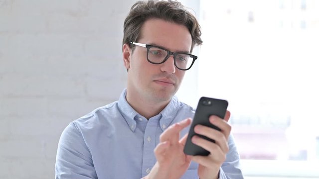 Portrait of Relaxed Young Man using Smartphone