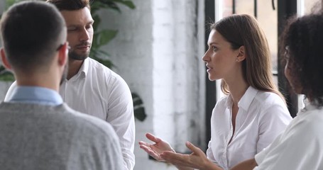 Confident female mentor teaching multiracial business people at training