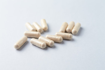 Korean Ginseng capsules. Concept for a healthy dietary supplementation. Bright paper background. Close up.