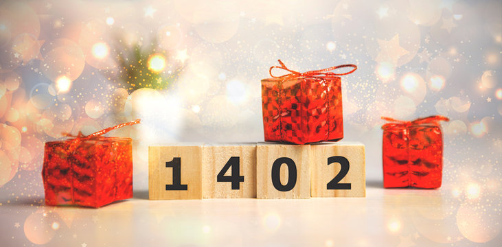 Happy Valentine Day on wooden blocks for February 14 with red gift and pretty bokeh background