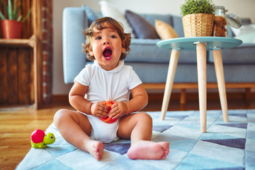 Beautiful toddler child girl playing with toys on the carpet