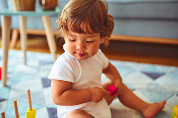 Beautiful toddler child girl playing with toys on the carpet