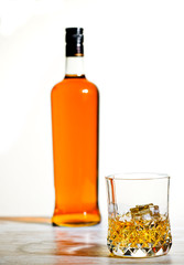 Whiskey in Crystal Tumbler with Bottle and White Background