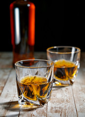 A bottle of whiskey and filled crystal tumbler
