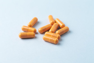 HMB (β-Hydroxy β-methylbutyric acid) capsules. Bodybuilding food supplements on bright paper background. Close up. 