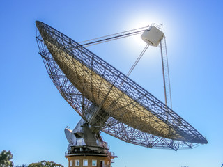 A radio telescope with the sun behind it