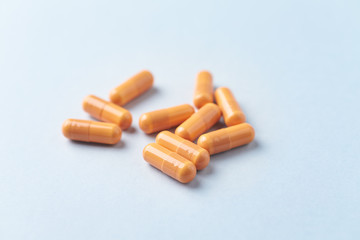 HMB (β-Hydroxy β-methylbutyric acid) capsules. Bodybuilding food supplements on bright paper background. Close up. 