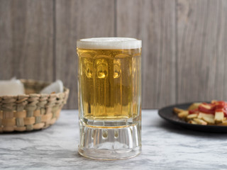 Cerveza con botana al fondo