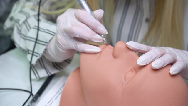 Cosmetologist making permanent makeup on a mannequin