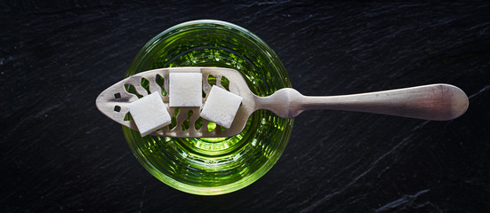 absinthe with sugar cubes and spoon flat lay composition - obrazy, fototapety, plakaty
