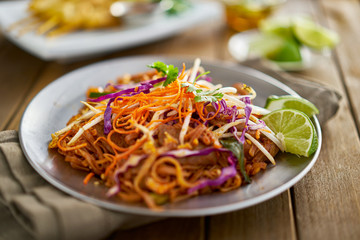 beef pad thai stir fry dish on plate with chopsticks