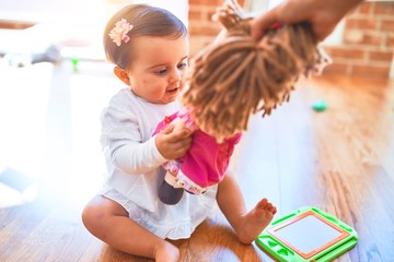 Obraz premium Beautiful infant happy at kindergarten around colorful toys playing with a doll