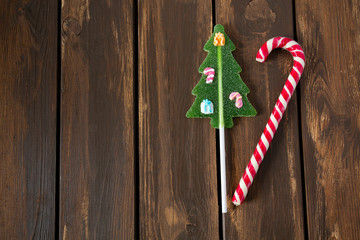 Striped and Christmas tree candies cane on wooden surface