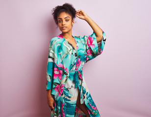 Young beautiful african american woman standing wearing elegant colorful caftan