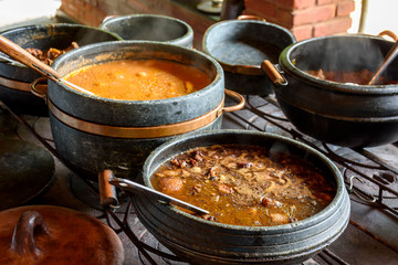 Traditional Brazilian food being prepared in clay pots and in the old and popular wood stove