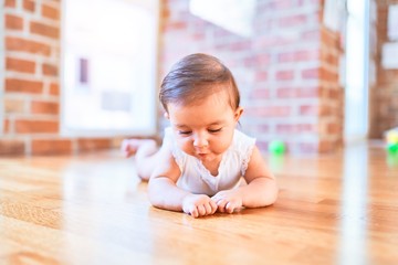 Beautiful infant happy at kindergarten around colorful toys