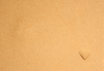 Heart symbol on a beach sand with soft sand background