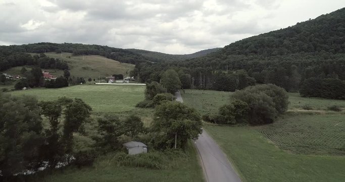 Aerial drone flight over a country road in cloudy weather