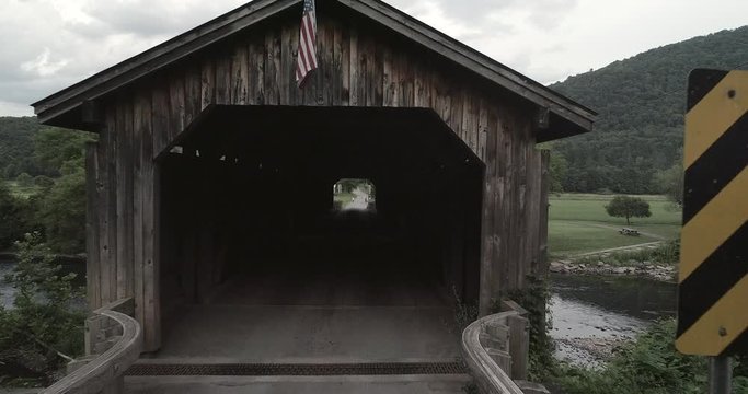 Drone flight into a single lane covered bridge in the countryside
