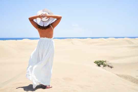 Young beautiful woman smiling happy enjoying summer vacation at maspalomas dunes beach