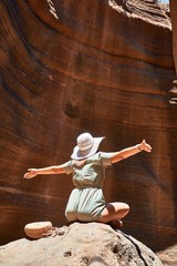 Young beauitufl hiker woman trekking natural orange mountain with arms raised celebrating summer holidays