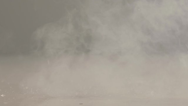 Frozen with liquid nitrogen tomato falling down and get crashed on the white background in the studio lights