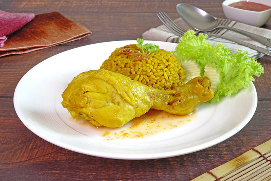 Biryani rice with chicken drumstick. Biryani, also known as biriyani, biriani, birani or briyani, is a mixed rice dish with its origins among the Muslims of the Indian subcontinent. Halal food.