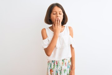 Young beautiful child girl wearing casual dress standing over isolated white background bored yawning tired covering mouth with hand. Restless and sleepiness.