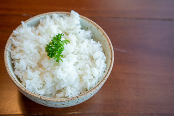 Small bowl of white rice with vegetable decorated on top.