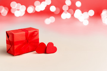 Two red hearts and red gift box on a white background with lights. Valentines day, love, romance, dating, gift present, anniversary concept with Copy space. Stock photo Valentine day card.