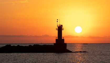 수평선 등대 너머에서 뜨는 태양