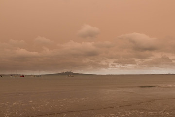 A haze from Australia's bushfires hangs over Torbay Beach, North Shore district of Auckland, New Zealand.