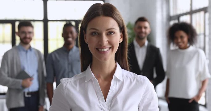 Smiling attractive female business leader looking at camera thumbs up