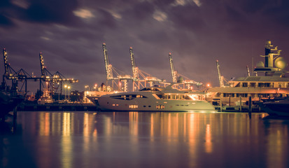 Fototapeta na wymiar miami harbor sea night cargo boats water sky clouds cranes industrial alubrado