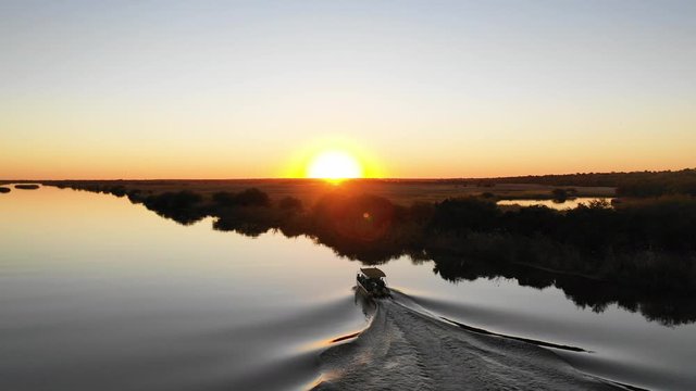 Aerial shot of boat driving into sunset in Namibia