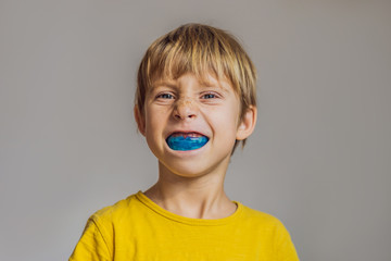 Six-year old boy shows myofunctional trainer. Helps equalize the growing teeth and correct bite, develop mouth breathing habit. Corrects the position of the tongue - Powered by Adobe