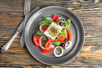 Plate of tasty Greek salad on table