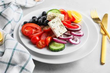 Plate with fresh Greek salad on table