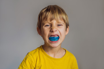 Six-year old boy shows myofunctional trainer. Helps equalize the growing teeth and correct bite, develop mouth breathing habit. Corrects the position of the tongue