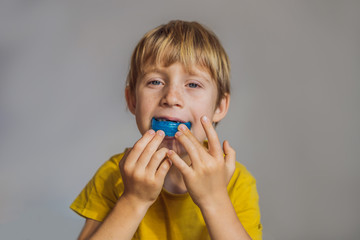 Six-year old boy shows myofunctional trainer. Helps equalize the growing teeth and correct bite, develop mouth breathing habit. Corrects the position of the tongue